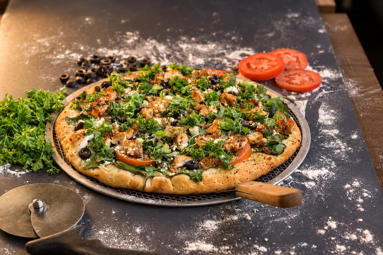 Fresh herb-topped Nayya pizza on the kitchen counter